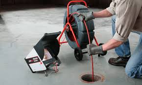 Technician using professional floor drain cleaning equipment