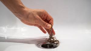 Hair clog being removed from a tub drain