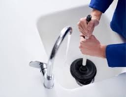 Bathroom sink drain being unclogged with plunger