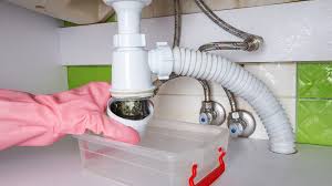 Under-sink plumbing drain trap being serviced